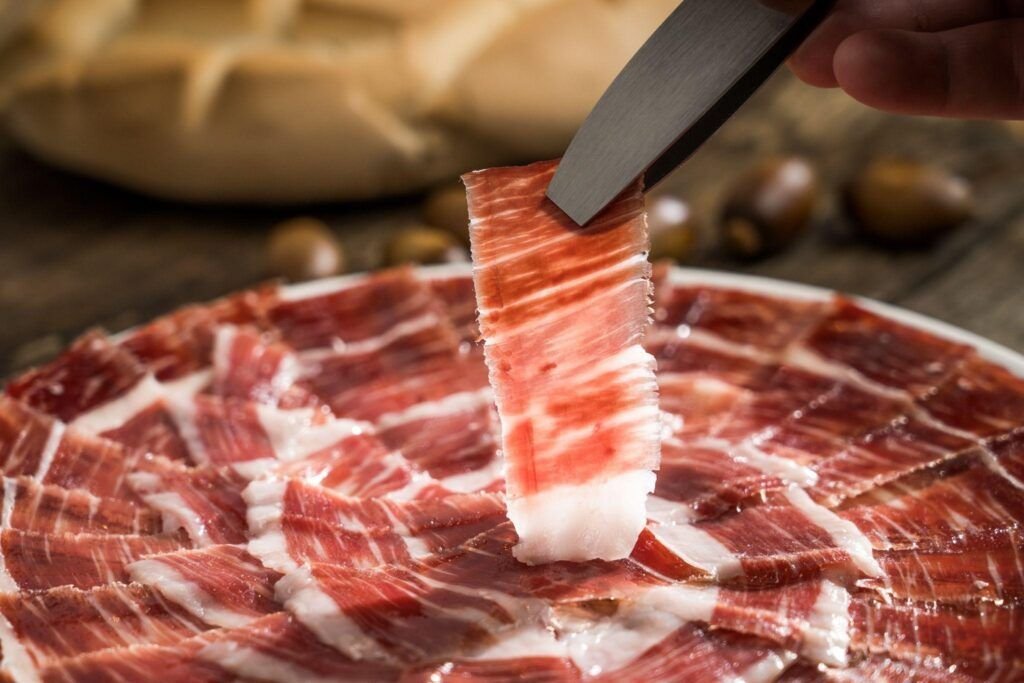 alt="jamon iberico de bellota cortado a cuchillo"